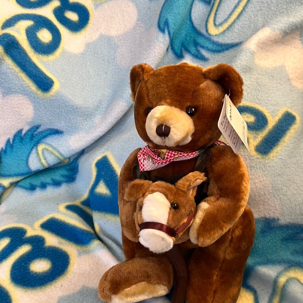 Plush bear on stick horse